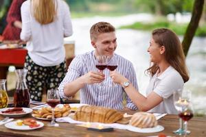 Freunde, die während der Sommerferien ein französisches Picknick im Freien haben foto