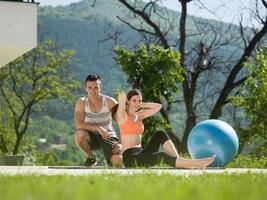 Frau mit persönlichem Trainer, die morgendliche Yoga-Übungen macht foto