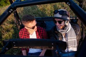 Zwei junge Männer, die ein Offroad-Buggy-Auto fahren foto