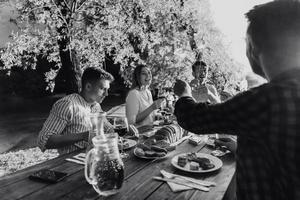 freunde feiern urlaub mit sprinklern und trinken rotwein, während sie ein französisches picknick-abendessen haben foto