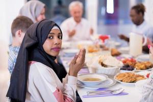 moderne schwarze muslimische frau, die vor dem iftar-abendessen betet foto