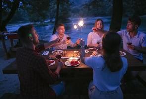 Freunde, die während der Sommerferien ein französisches Picknick im Freien haben foto