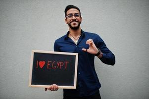 Ich liebe Ägypten. nahöstlicher mann trägt blaues hemd, brille, haltebrett. foto