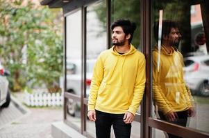 urbaner junger Hipster-Indianer in einem modischen gelben Sweatshirt. Cooler südasiatischer Typ trägt Hoodie. foto