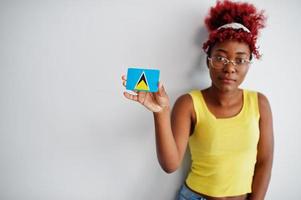 afroamerikanerin mit afrohaar, trägt gelbes unterhemd und brille, hält st. lucia flagge isoliert auf weißem hintergrund. foto