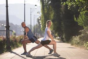 Paar Aufwärmen und Dehnen vor dem Joggen foto