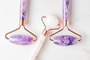 Gesichtsroller Guasha-Massagegeräte. Gesichtspflege und Anti-Age-Produkte. chinesische gua sha massagegeräte aus rosenquarz und amethyst. Nahaufnahme, Ansicht von oben foto