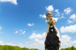 Babypilot, in einem Pilotenhut, Helm, an den Händen eines jungen, schönen brünetten Mädchens. Platz kopieren. foto