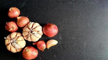 Bund Zwiebeln und Knoblauch auf schwarzem Hintergrund foto