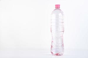 Plastikflasche des Trinkwassers lokalisiert auf Weiß foto