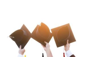 Nahaufnahme graduierten Hand halten zeigen Hut im Hintergrund Schulgebäude. schuss der abschlusskappe während des beginns des universitätsabschlusses, bildungsstudentenerfolgslernkonzept foto