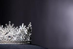 Diamant-Silberkrone für Miss-Schönheitswettbewerb, Kristall-Tiara-Schmuck verziert mit Edelsteinen und abstrakter dunkler Hintergrund auf schwarzem Samtstoff, Makrofotografie-Kopienraum für Textlogo foto