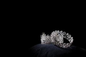 Diamant-Silberkrone für Miss-Schönheitswettbewerb, Kristall-Tiara-Schmuck verziert mit Edelsteinen und abstrakter dunkler Hintergrund auf schwarzem Samtstoff, Makrofotografie-Kopienraum für Textlogo foto