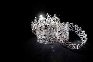 Diamant-Silberkrone für Miss-Schönheitswettbewerb, Kristall-Tiara-Schmuck verziert mit Edelsteinen und abstrakter dunkler Hintergrund auf schwarzem Samtstoff, Makrofotografie-Kopienraum für Textlogo foto