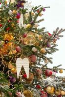 Nahaufnahme von Christbaumschmuck mit Kugeln und Schnee-Zuckerguss. festliche grußkarte für den winterurlaub in goldenen farben. foto