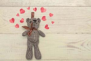 Valentinstag. Liebesherz aus Papier. Teddybär. kreative grußkarte auf holz. foto