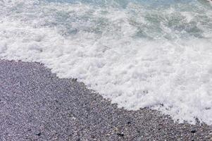 Kieselküste. Küste mit transparentem Wasser und kleinen Steinen foto