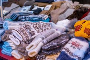 Stall mit gestrickten Wollfäustlingen. Zubehör für Winterkleidung. foto