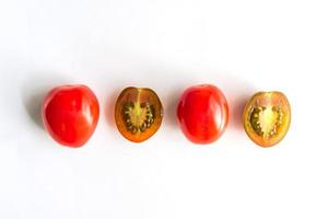 reife rote und grüne Kirschtomaten in Folge. Ganze und Hälften von Gemüse auf weißem Hintergrund foto