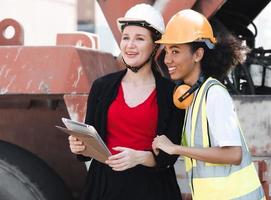 vielfältige gruppe von menschen, die am containerterminal zusammenarbeiten. Afroamerikanische Vorarbeiterin und Wirtschaftsingenieurin, Managerin, die im Containerdepot steht. Vielfalt Geschäftsleute Konzept. foto