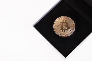 Gold-Bitcoin in einer weißen Geschenkbox mit schwarzem Samt auf weißem Hintergrund. Platz kopieren. foto