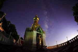 Milchstraße am Standing Gold Buddha Bildname ist Wat Sra Song Pee Nong in Phitsanulok, Thailand foto