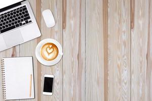 draufsicht laptop oder notebook, handy und tasse latte art kaffee auf holztisch. Geschäftsvorlagenmodell zum Hinzufügen Ihres Textes. foto