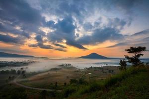 nebliger Morgensonnenaufgang und Straße im Berg bei khao-kho phetchabun, Thailand foto