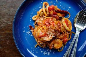 Spaghetti Meeresfrüchte Tomatensauce auf Holztisch foto