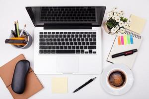 draufsicht laptop oder notebook-arbeitsbereich büro auf weißem tisch foto