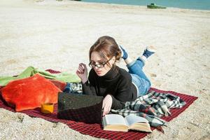 junge Frau genießt ihre Arbeit am Strand foto
