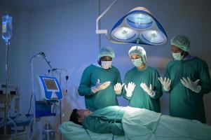 gruppe von professionellen chirurgen gemischter rassen, die im krankenhaus-operationssaal operieren, gesundheitskonzept. foto