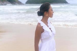 Schöne junge Frau mit weißem Kleid am Strand an Feiertagen, Reisen, Romantik, Hochzeitskonzept foto