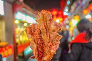 nahaufnahme gegrilltes lampenbein street food in wangfujing walking street und street food in peking stadt, china reise foto