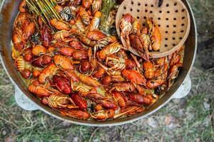 gekochte rote Krebse oder Langusten mit Kräutern. Krebse, die im Topf auf dem Feuer kochen foto