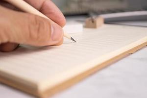 hand halten bleistift schreiben auf papier notiz konzept bildung oder arbeit im büro foto