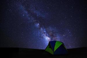 landschaft mit milchstraßengalaxie, sternenhimmel mit sternen und silhouette des kuppelzeltes foto