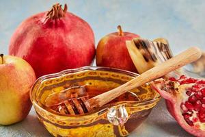 rosh hashanah - jüdisches neujahrsfeiertagskonzept. apfelförmige Schüssel mit Honig, Äpfel, Granatäpfel, ein Schofar sind traditionelle Symbole des Feiertags foto