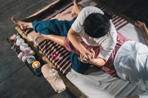 massage und spa entspannende behandlung des office-syndroms traditioneller thailändischer massagestil. asain senior weibliche Masseurin, die Massage behandelt Hand, Rückenschmerzen, Armschmerzen, Fuß und Stress für alte Frau müde. foto