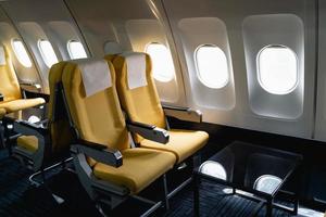 passagierflugzeugsitze in der kabine. innenraum von verkehrsflugzeugen auf ihren sitzen während des fluges in der Economy-Class-Passagierabteilung von Flugzeugen. foto