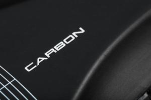 Carbon-Element von Radschuhen mit der Aufschrift Carbon auf schwarzem Hintergrund. foto
