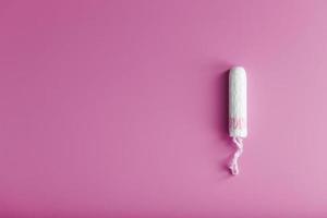 Hygienischer Tampon auf rosafarbenem Hintergrund mit freiem Platz foto
