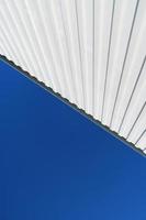 strukturierte weiße Metallstrukturen diagonal gegen einen blauen Himmel. foto