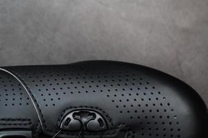 sportschuhe aus schwarzem perforiertem leder in einem dunklen schlüssel. foto