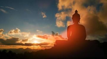 Buddha-Silhouette auf goldenem Sonnenuntergang Hintergrund Überzeugungen des Buddhismus foto