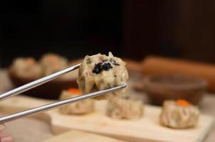 nahaufnahme chinesisches gedämpftes dimsum oder dim sum, auf essstäbchen, traditionelle küche foto