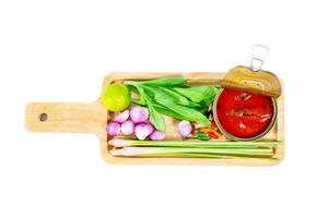 Makrele in Tomatensauce mit Schneidebrett und Gemüse im Hintergrund foto