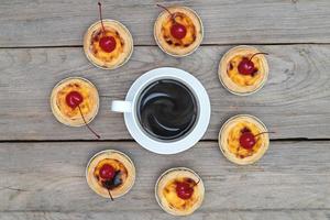 Kaffeetasse mit Eierkuchen auf Holztisch, Draufsicht foto