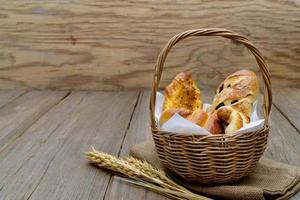 Verschiedenes Frischkäsewurstbrot im Korb auf hölzernem Hintergrund foto