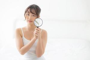 schöne junge asiatische frau mit vergrößerung der haut ein problem der akne, schönheit asia mädchen überprüfen hautpflege des gesichts, weibliche analysieren probleme, kosmetik und make-up, gesundheits- und pflegekonzept. foto